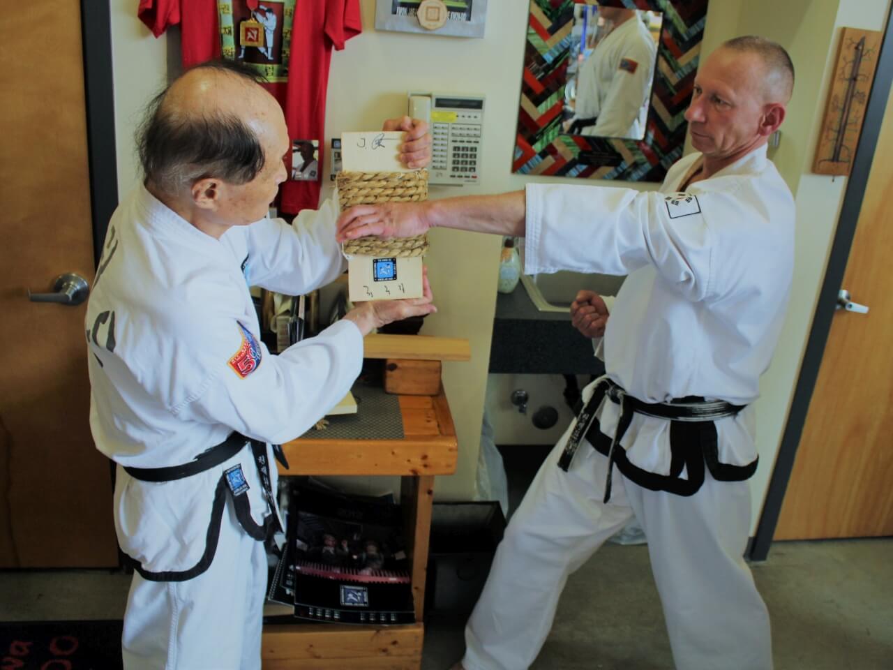 Joachim bekommt ein von Großmeister Kwon handgefertigtes Target aus Reisstro. Hier zeigt er einen Handkantenschlag.